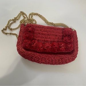 Red woven straw bag with pom pom details crossbody